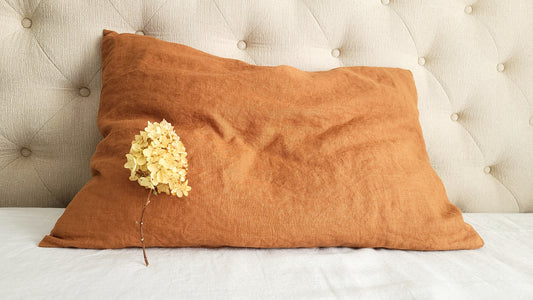 Linen pillow in cinnamon color on the bed